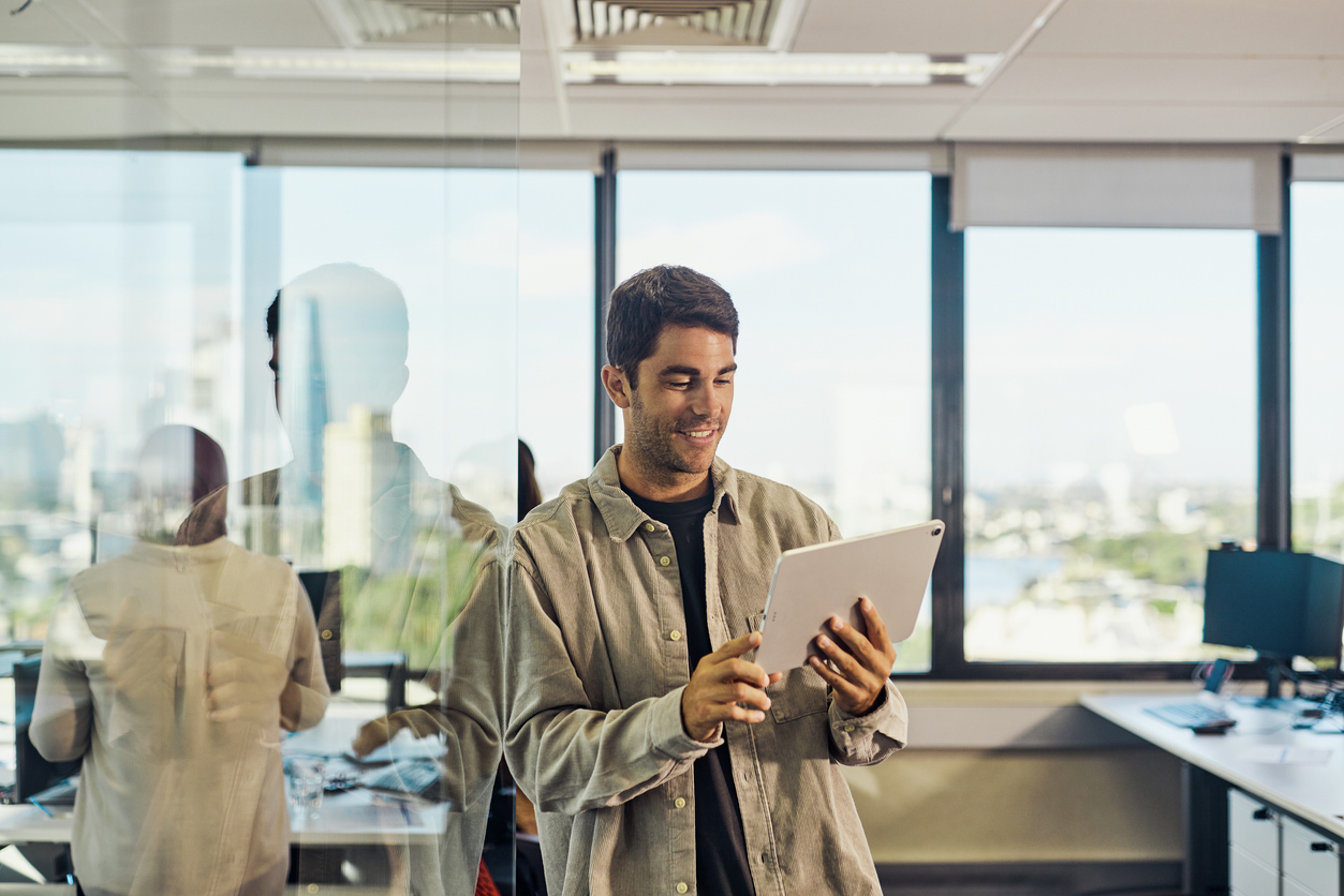 Business director reviewing reports on a tablet in a modern office, representing proactive IT management and seamless business operations